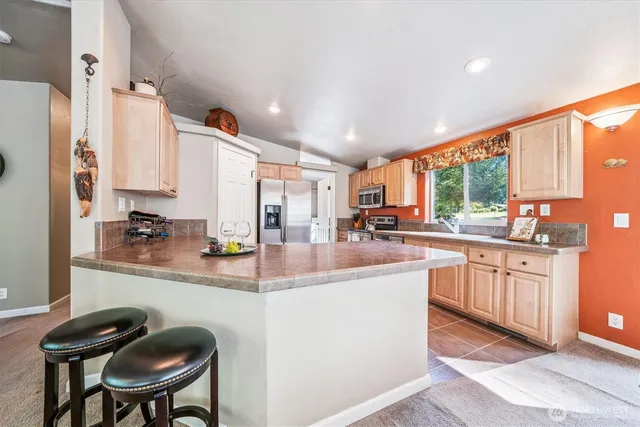 a kitchen with stainless steel appliances granite countertop a sink and a refrigerator