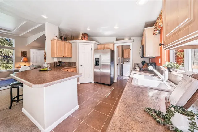 a kitchen with stainless steel appliances granite countertop a sink and a refrigerator