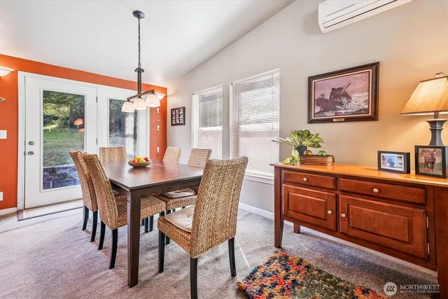 a dining room with furniture a chandelier and wooden floor