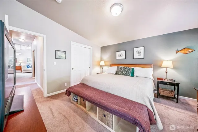 a bedroom with a large bed and a lamp on table