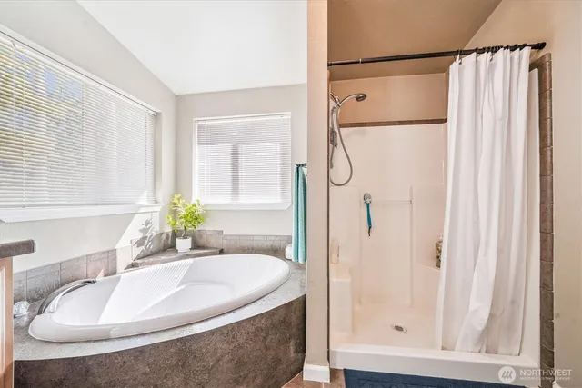 a bathroom with a granite countertop bathtub shower and a sink