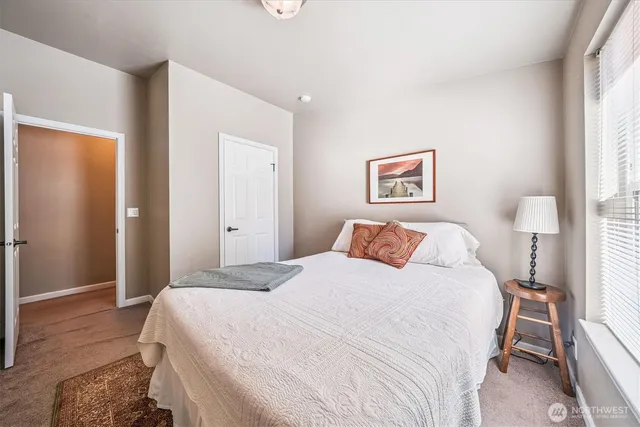 a bedroom with a bed and a painting on the wall