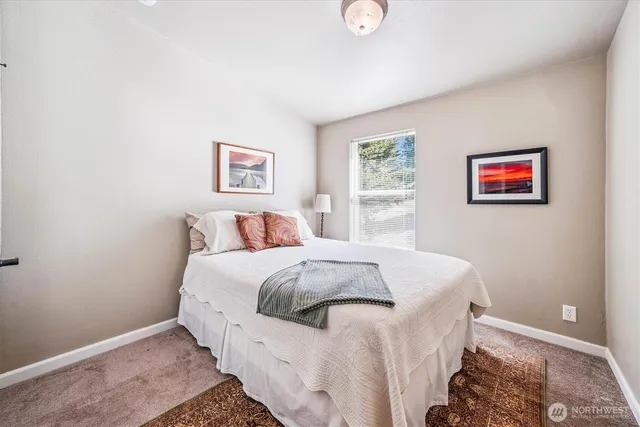 a bed room with a bed and a painting on the wall