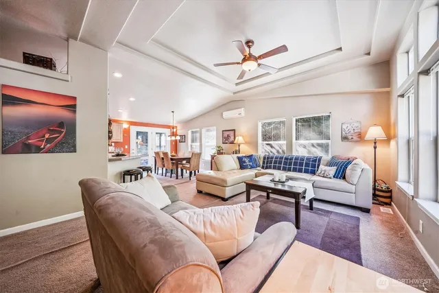 a living room with furniture kitchen view and a wooden floor