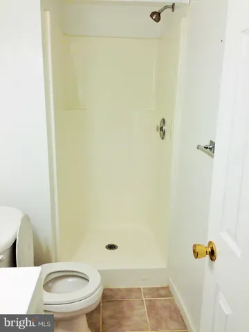a white toilet sitting next to a shower