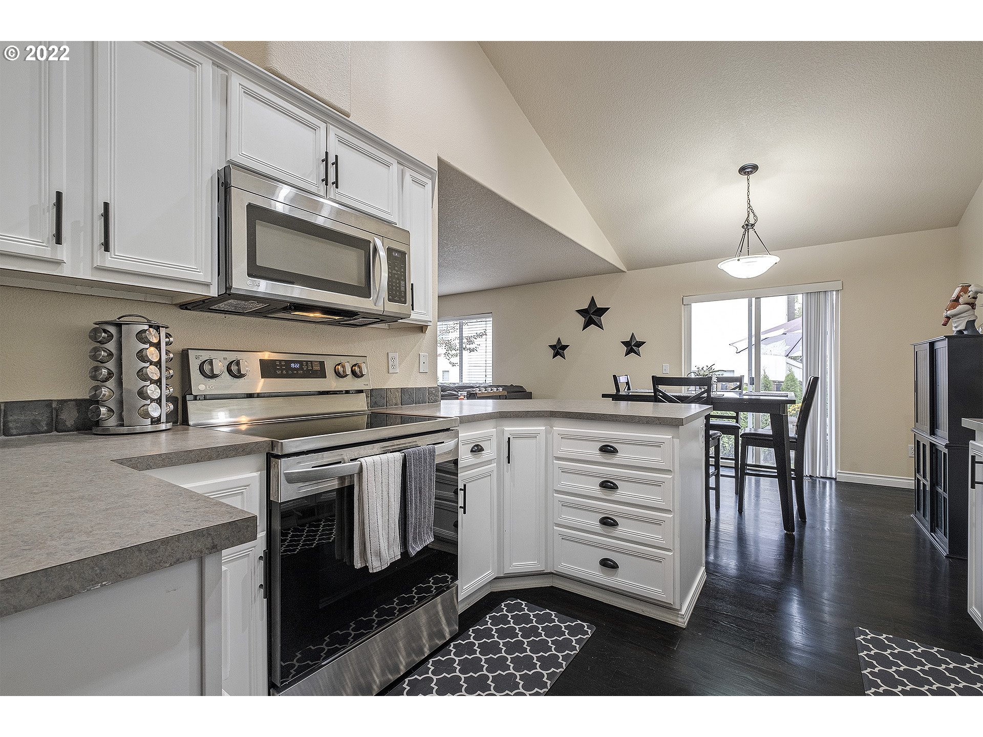 40348 Therese Street Sandy, OR 97055 - Photo 14 of 28 a kitchen with stainless steel appliances granite countertop a stove a sink dishwasher a microwave oven with cabinets and wooden floor