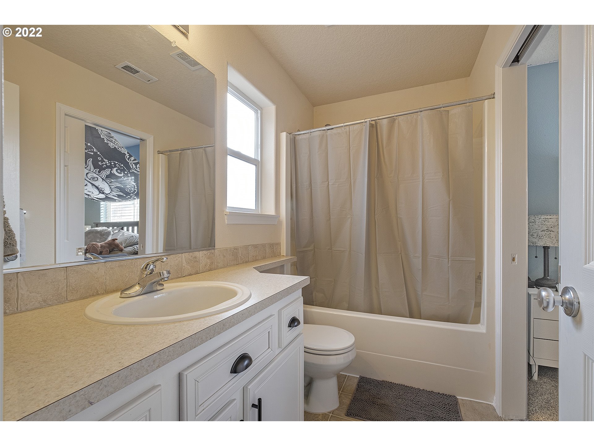40348 Therese Street Sandy, OR 97055 - Photo 22 of 28 a bathroom with a sink toilet a mirror and shower curtain