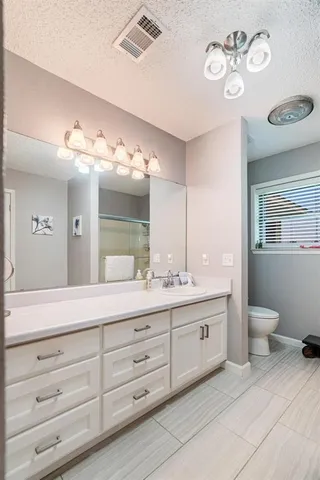 a spacious bathroom with a granite countertop sink mirror and toilet