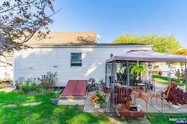 a front view of a house with garden and sitting area