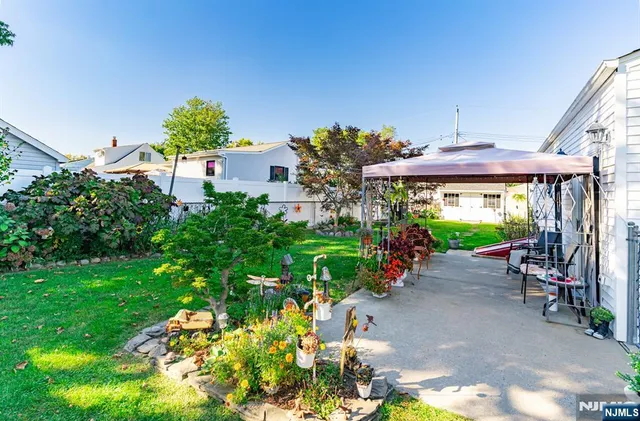 a view of a patio with plants and a table and chairs under an umbrella
