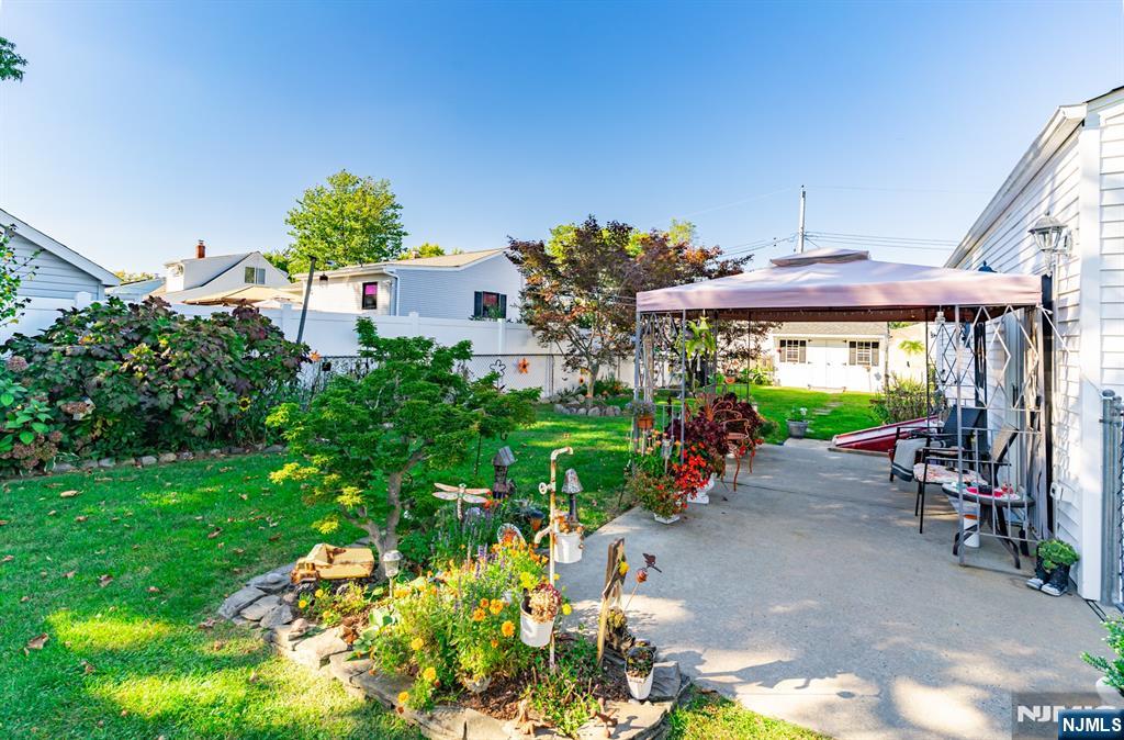 8 Lynn Boulevard Hazlet, NJ 07730 - Photo 23 of 25 a view of a patio with plants and a table and chairs under an umbrella