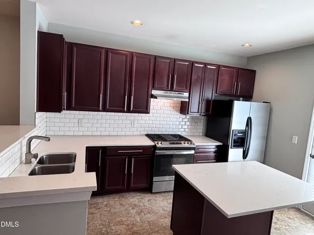 a kitchen with a sink cabinets and wooden floor