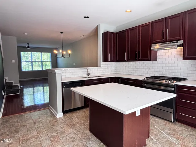 an empty room with wooden floor a fireplace and a ceiling fan