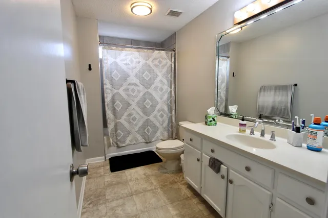 a bathroom with double vanity and a mirror