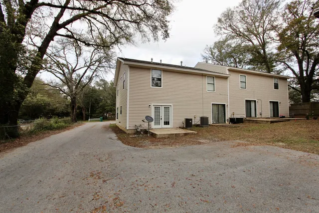a view of a white house with a yard and large tree