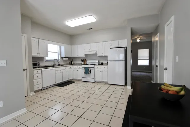 a kitchen with a cabinets a sink a window and stainless steel appliances