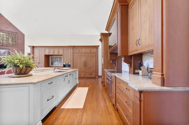 a large kitchen with stainless steel appliances granite countertop a lot of counter space and wooden floor