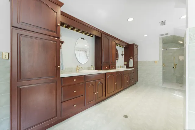 a bathroom with a double vanity sink mirror and shower