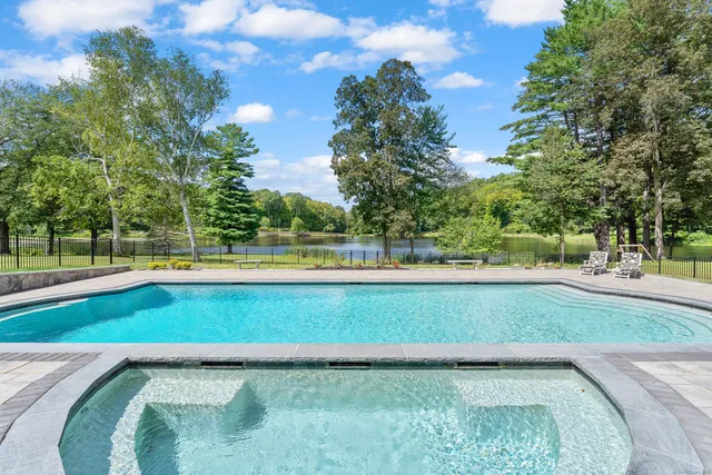 a view of swimming pool with a yard and trees