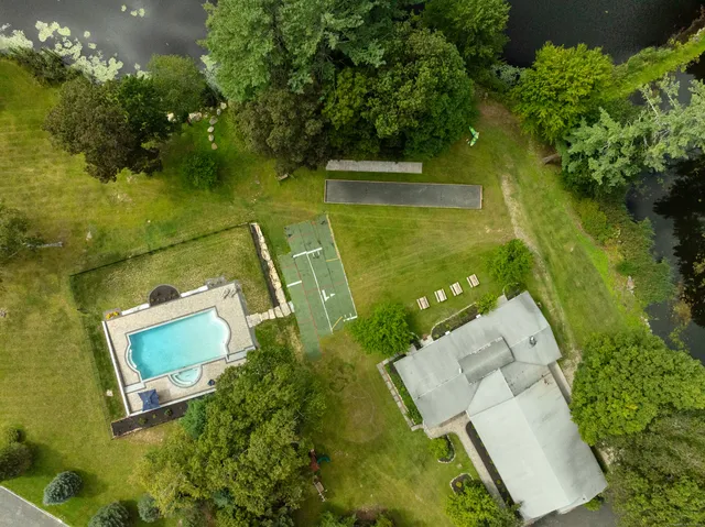 an aerial view of a house with a yard and lake view