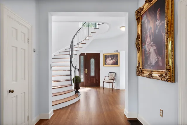 a view of a hallway with wooden floor and staircase