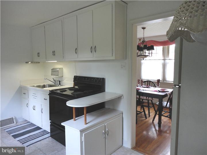 642 Dutton Circle Springfield, PA 19064 - Photo 11 of 25 a kitchen with stainless steel appliances kitchen island granite countertop a table and chairs in it