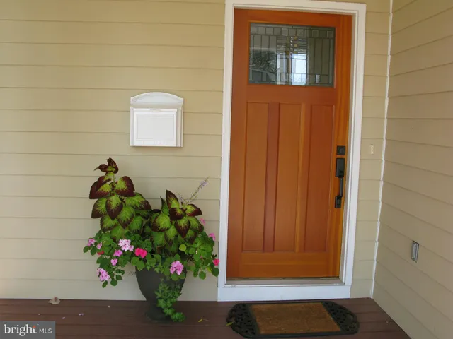 a view of a hallway with wooden floor and closet