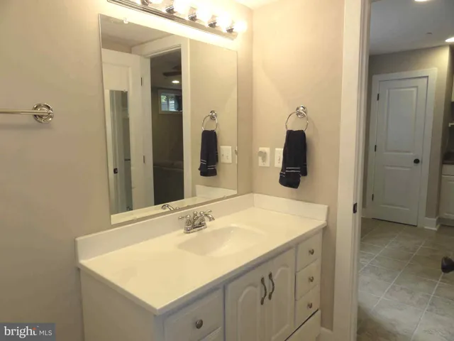a view of an empty room with cabinet and mirrors