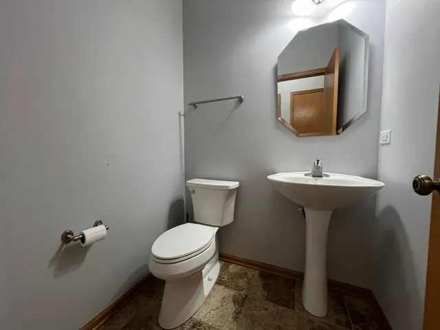 a bathroom with a toilet sink and mirror