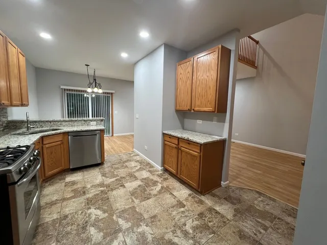 a large kitchen with stainless steel appliances granite countertop a stove a sink and a refrigerator