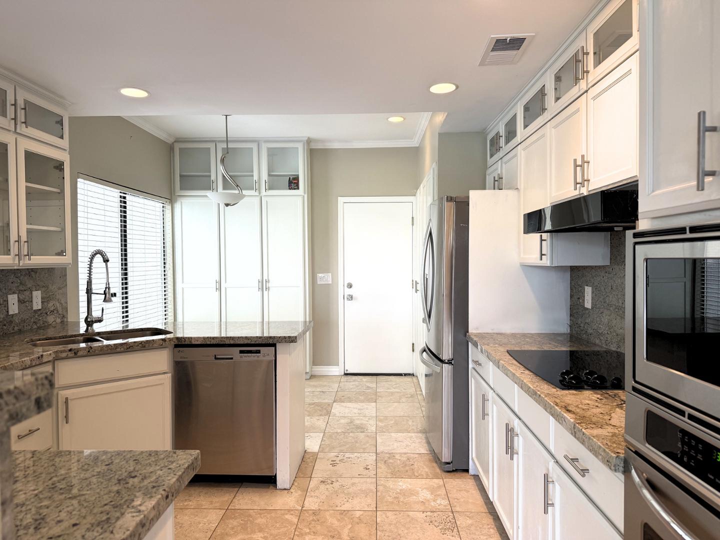 7272 East Gainey Ranch Road, Unit 19 Scottsdale, AZ 85258 - Photo 8 of 13 a kitchen with stainless steel appliances granite countertop a refrigerator and a sink