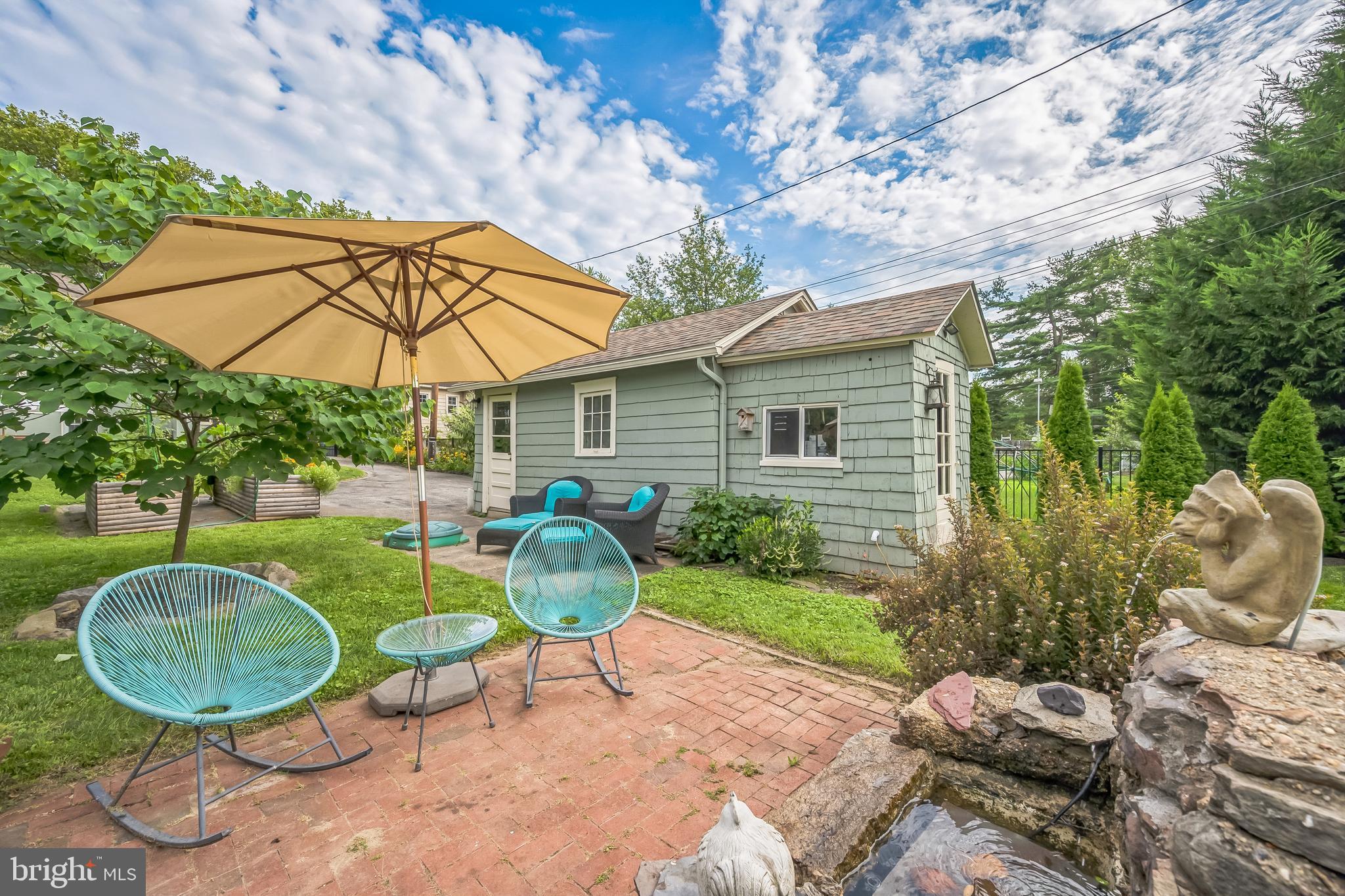 35 Harvard Road Audubon, NJ 08106 - Photo 33 of 36 a backyard of a house with table and chairs under an umbrella