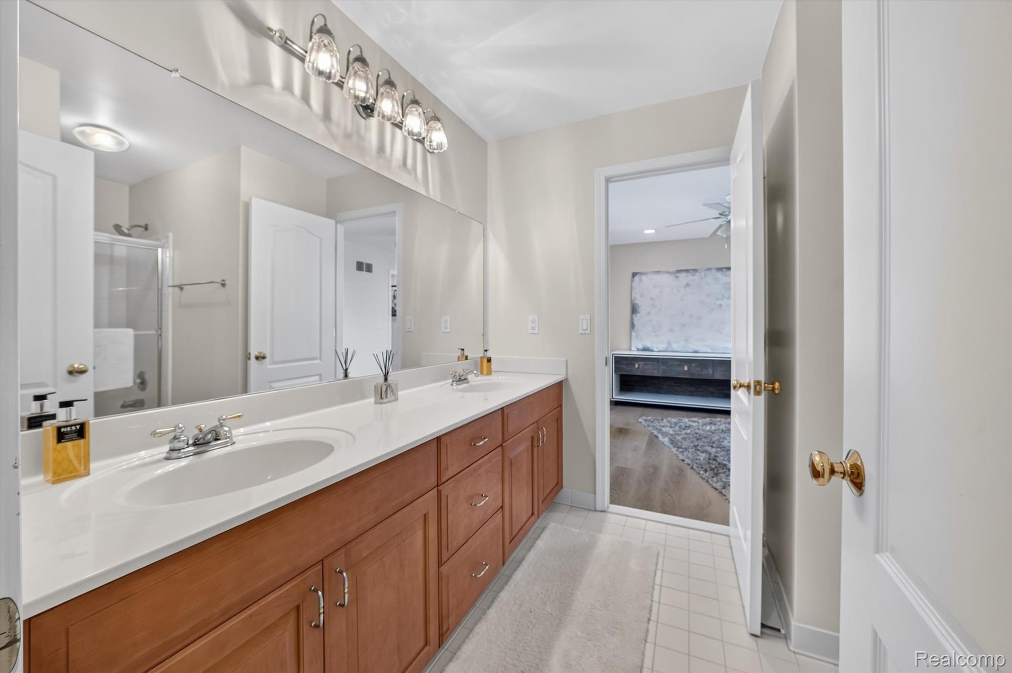 3804 Elk Drive Rochester, MI 48306 - Photo 30 of 75 Jack and Jill Bathroom featuring a dual vanity with white countertops, warm wood-finish cabinetry, and brushed nickel hardware
