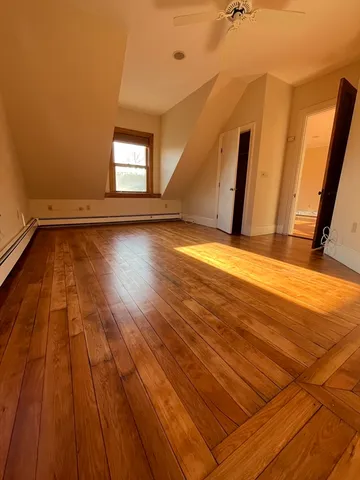a view of a room with wooden floor and window