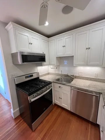 a kitchen with granite countertop a stove and a sink