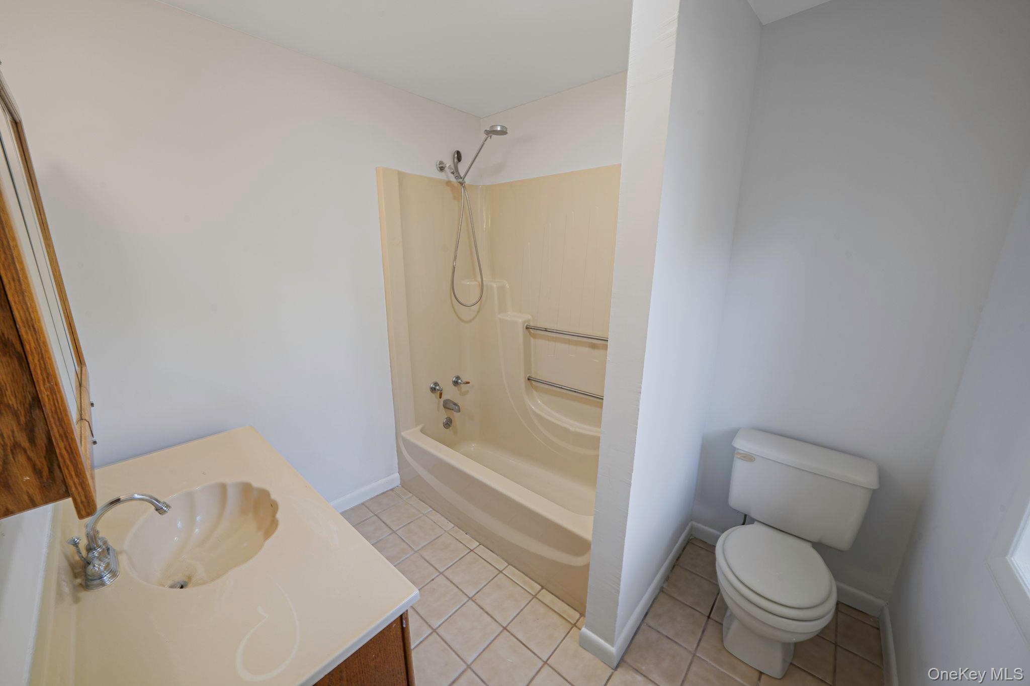 60 Hawthorne Road Rocky Point, NY 11778 - Photo 12 of 23 Full bath with light tile patterned flooring, shower / bath combination, and vanity