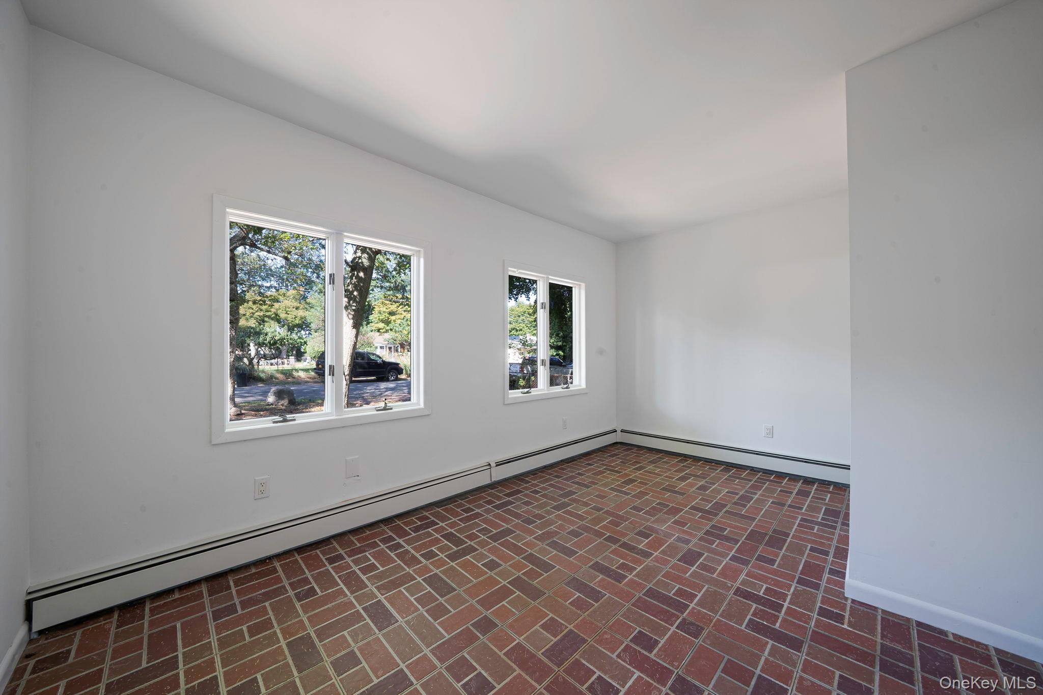60 Hawthorne Road Rocky Point, NY 11778 - Photo 16 of 23 Unfurnished room with a baseboard radiator and brick patterned floors