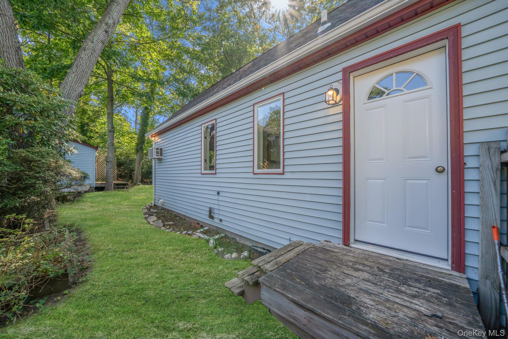 60 Hawthorne Road Rocky Point, NY 11778 - Photo 21 of 23 Property entrance with a shingled roof, a lawn, and a wooden deck