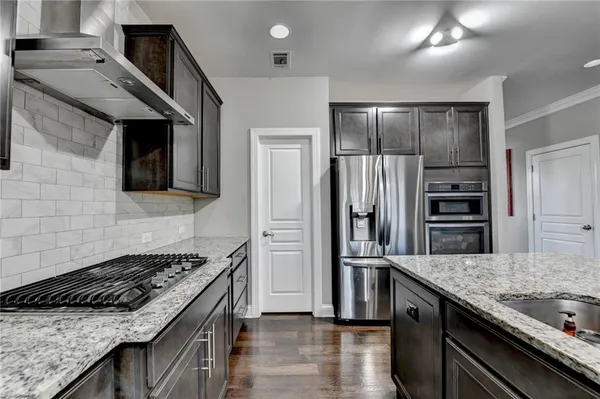 a kitchen with stainless steel appliances granite countertop a sink stove and refrigerator