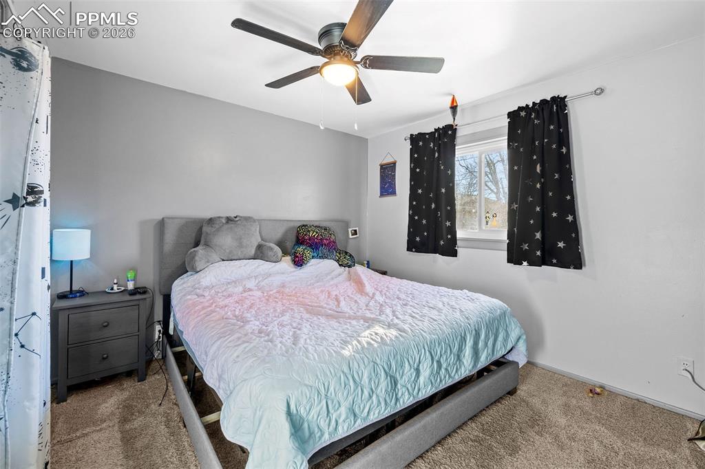 26 Easy Street Colorado Springs, CO 80911 - Photo 14 of 19 a bedroom with a bed a dresser and a window