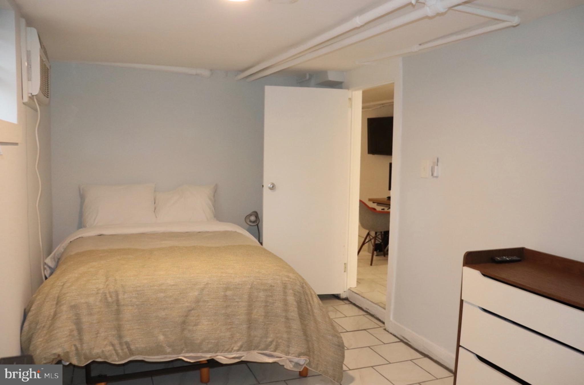 2121 N Street Northwest, Unit 2 Washington, DC 20037 - Photo 3 of 8 a bedroom with a bed and wooden floor