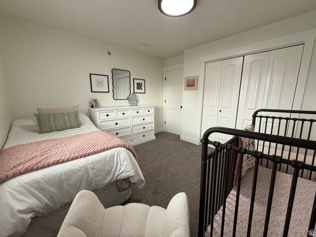 608 South 500 West, Unit 3 Provo, UT 84601 - Photo 30 of 35 Carpeted room featuring a white paneled closet, a white dresser with black hardware, and a single paneled door with black hardware