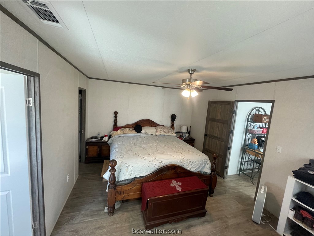 11320 Old Hearne Road Bryan, TX 77807 - Photo 6 of 26 a bedroom with a bed and a chandelier