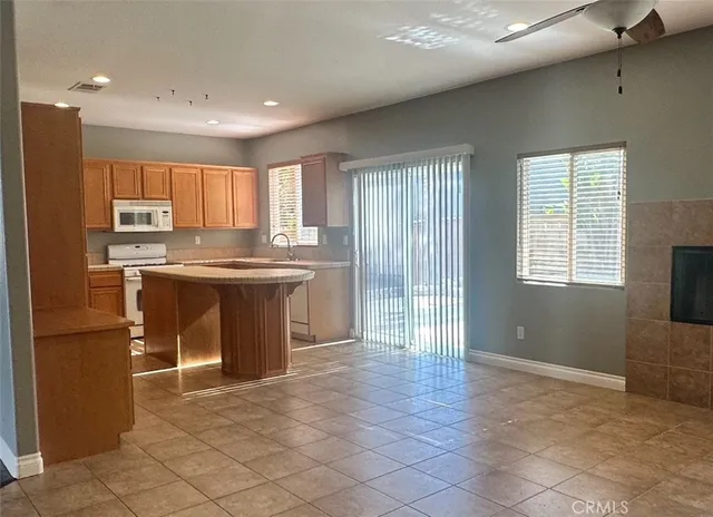 a kitchen with kitchen island granite countertop a sink stove and cabinets
