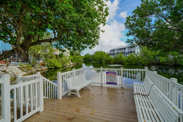 a view of deck and patio with swimming pool and wooden fence