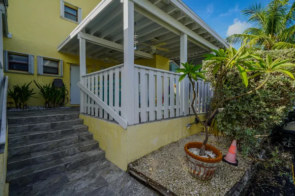a backyard of a house with wooden floor barbeque oven and plants