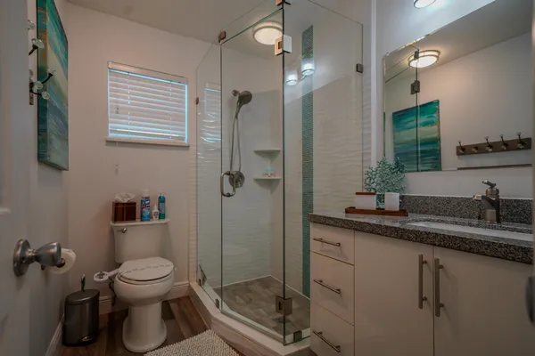 a bathroom with a granite countertop toilet sink and shower