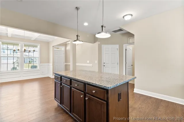 a kitchen with a counter space wooden floor and a window