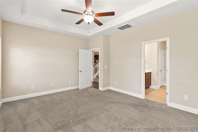 an empty room with closet and a ceiling fan