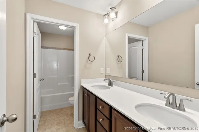 a bathroom with a sink double vanity granite tub and shower